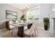Bright dining room with modern chandelier, neutral colored walls and large window views at 9330 Meadow Hunt Way, Winter Garden, FL 34787