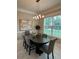 Dining room features modern chandelier, large window, dining table with gray chairs and abstract wall art at 9330 Meadow Hunt Way, Winter Garden, FL 34787