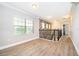 Upstairs hallway with laminate wood flooring, leading to an adjacent sitting area with views of outdoors at 9330 Meadow Hunt Way, Winter Garden, FL 34787