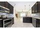 Modern kitchen features dark cabinets, granite countertops, and stainless steel appliances at 9330 Meadow Hunt Way, Winter Garden, FL 34787