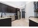 Modern kitchen featuring dark cabinets, granite countertops, stainless steel appliances, and tile floors at 9330 Meadow Hunt Way, Winter Garden, FL 34787