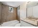 This remodeled bathroom features wood-look wall tile, a granite vanity, and a combined shower and tub at 239 S Lake Cortez Dr, Apopka, FL 32703