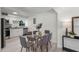 Bright dining space with a glass table, gray chairs, and white walls, adjacent to kitchen at 239 S Lake Cortez Dr, Apopka, FL 32703