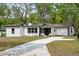 A single-story home features a crisp white exterior with black accents and a freshly poured concrete driveway at 239 S Lake Cortez Dr, Apopka, FL 32703