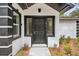 A modern black front door is flanked by sidelights and contrasted by a white exterior with black trim at 239 S Lake Cortez Dr, Apopka, FL 32703