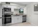 Modern kitchen with stainless steel appliances, granite countertops, and white cabinetry at 239 S Lake Cortez Dr, Apopka, FL 32703