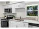 Well-lit kitchen featuring stainless steel appliances, granite counters, and white cabinetry at 239 S Lake Cortez Dr, Apopka, FL 32703