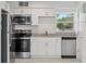 Bright kitchen with white cabinets, stainless appliances, and granite countertops offers a clean, modern design at 239 S Lake Cortez Dr, Apopka, FL 32703