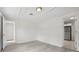 A bright, neutral room with light gray floors, white walls, and a glimpse into a small kitchen area at 239 S Lake Cortez Dr, Apopka, FL 32703