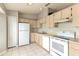 Functional kitchen featuring white appliances, light wood cabinets, and tiled flooring at 294 San Gabriel St, Winter Springs, FL 32708