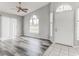 Bright living room featuring a ceiling fan, wood floors, large windows, and a white entry door at 294 San Gabriel St, Winter Springs, FL 32708