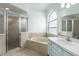 Bathroom with a large tub, glass-enclosed shower, and sink, perfect for relaxing and unwinding at 321 Moffat Loop, Oviedo, FL 32765
