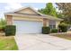 Home featuring an attached two-car garage and driveway with a well-manicured lawn at 321 Moffat Loop, Oviedo, FL 32765