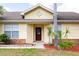 Charming home featuring a brick facade, well-manicured landscaping, and a striking red front door at 321 Moffat Loop, Oviedo, FL 32765