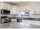 Well-lit kitchen with granite countertops, stainless steel appliances, and white cabinetry at 321 Moffat Loop, Oviedo, FL 32765