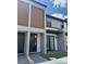 Modern townhome with neutral tones, wooden accents, and stylish front door at 3296 Tranquil Trl, Kissimmee, FL 34747