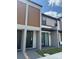 View of a modern home with dark accents, sliding glass door, and a paved walkway at 3296 Tranquil Trl, Kissimmee, FL 34747