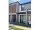 Modern townhome featuring a covered patio with a sliding glass door and outdoor seating at 3296 Tranquil Trl, Kissimmee, FL 34747