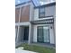 Modern townhome featuring a covered patio with a sliding glass door and a gray facade at 3296 Tranquil Trl, Kissimmee, FL 34747