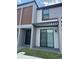 Modern townhome showcasing a covered patio, sliding glass door, and a contemporary exterior at 3296 Tranquil Trl, Kissimmee, FL 34747