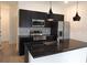 Modern kitchen boasts a spacious island, black cabinetry, and stainless steel appliances at 3296 Tranquil Trl, Kissimmee, FL 34747