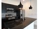A modern kitchen featuring dark cabinetry, stainless steel appliances, and granite countertops at 3296 Tranquil Trl, Kissimmee, FL 34747