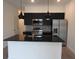 Modern kitchen boasts a spacious island, black cabinetry, and stainless steel appliances at 3296 Tranquil Trl, Kissimmee, FL 34747