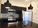Modern kitchen boasts a spacious island, black cabinetry, and stainless steel appliances at 3296 Tranquil Trl, Kissimmee, FL 34747