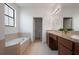 Spacious bathroom featuring a garden tub, separate vanities, and abundant natural light at 1969 Portofino Meadows Blvd, Orlando, FL 32824