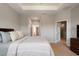 Primary bedroom with cozy decor, tray ceiling, and access to en-suite bath at 1969 Portofino Meadows Blvd, Orlando, FL 32824
