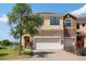 Charming two-story townhome showcasing a brick-accented facade, attached garage, and picturesque landscaping at 1969 Portofino Meadows Blvd, Orlando, FL 32824