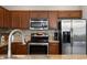 Modern kitchen featuring stainless appliances, granite countertops, and a stylish tile backsplash at 1969 Portofino Meadows Blvd, Orlando, FL 32824