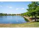 Picturesque lake view with lush trees lining the water's edge and beautiful homes in the distance at 1969 Portofino Meadows Blvd, Orlando, FL 32824
