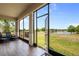 Enjoy lake views from the screened lanai featuring wood-look tile floors and comfortable seating at 1969 Portofino Meadows Blvd, Orlando, FL 32824