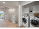 Convenient second-floor laundry area with a washer and dryer, shelving, and additional storage at 1969 Portofino Meadows Blvd, Orlando, FL 32824