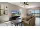 Bright living room featuring tile flooring, a ceiling fan, and expansive windows with a view of the lake at 1969 Portofino Meadows Blvd, Orlando, FL 32824