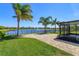 View of a backyard featuring a brick patio, screened-in lanai, and a serene lake view at 2987 Gibraltar Blvd, New Smyrna Beach, FL 32168