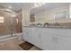 Primary bathroom featuring double sinks, granite counters, and a glass shower enclosure at 4730 Coral Castle Dr, Kissimmee, FL 34746
