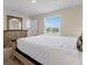 Bright bedroom with a view of the lake, featuring a light-colored dresser and a king-sized bed at 4730 Coral Castle Dr, Kissimmee, FL 34746