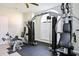 A well-equipped exercise room with multiple machines and a large arched window at 4730 Coral Castle Dr, Kissimmee, FL 34746