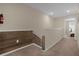 Upstairs hallway featuring wood-accented half wall and neutral carpeting at 4730 Coral Castle Dr, Kissimmee, FL 34746