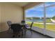 Screened lanai with a table and chairs overlooking a serene lake at 4730 Coral Castle Dr, Kissimmee, FL 34746
