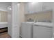 Convenient laundry room equipped with a washer, dryer, and overhead storage cabinets at 4730 Coral Castle Dr, Kissimmee, FL 34746