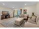 Comfortable living room with tile flooring, neutral furniture, and a view of the screened lanai at 4730 Coral Castle Dr, Kissimmee, FL 34746