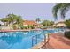Community pool with lounge chairs and tables, surrounded by palm trees and low shrubs at 4730 Coral Castle Dr, Kissimmee, FL 34746