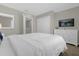 Bedroom with a white bed, dresser with a tv, a mirror, and a closet at 4732 Coral Castle Dr, Kissimmee, FL 34746
