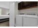 Convenient laundry room features overhead storage, washer, and dryer, with adjacent bedroom access at 4732 Coral Castle Dr, Kissimmee, FL 34746