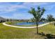 Scenic view of a community pond with walking path and lush landscaping at 4732 Coral Castle Dr, Kissimmee, FL 34746
