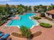 Stunning community pool with a unique shape, landscaped surroundings, and plenty of lounge chairs for relaxation at 4732 Coral Castle Dr, Kissimmee, FL 34746