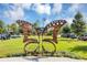 A majestic metal butterfly statue sits proudly on a lush green lawn in front of a modern building on a sunny day at 8896 Reymont St, Orlando, FL 32827